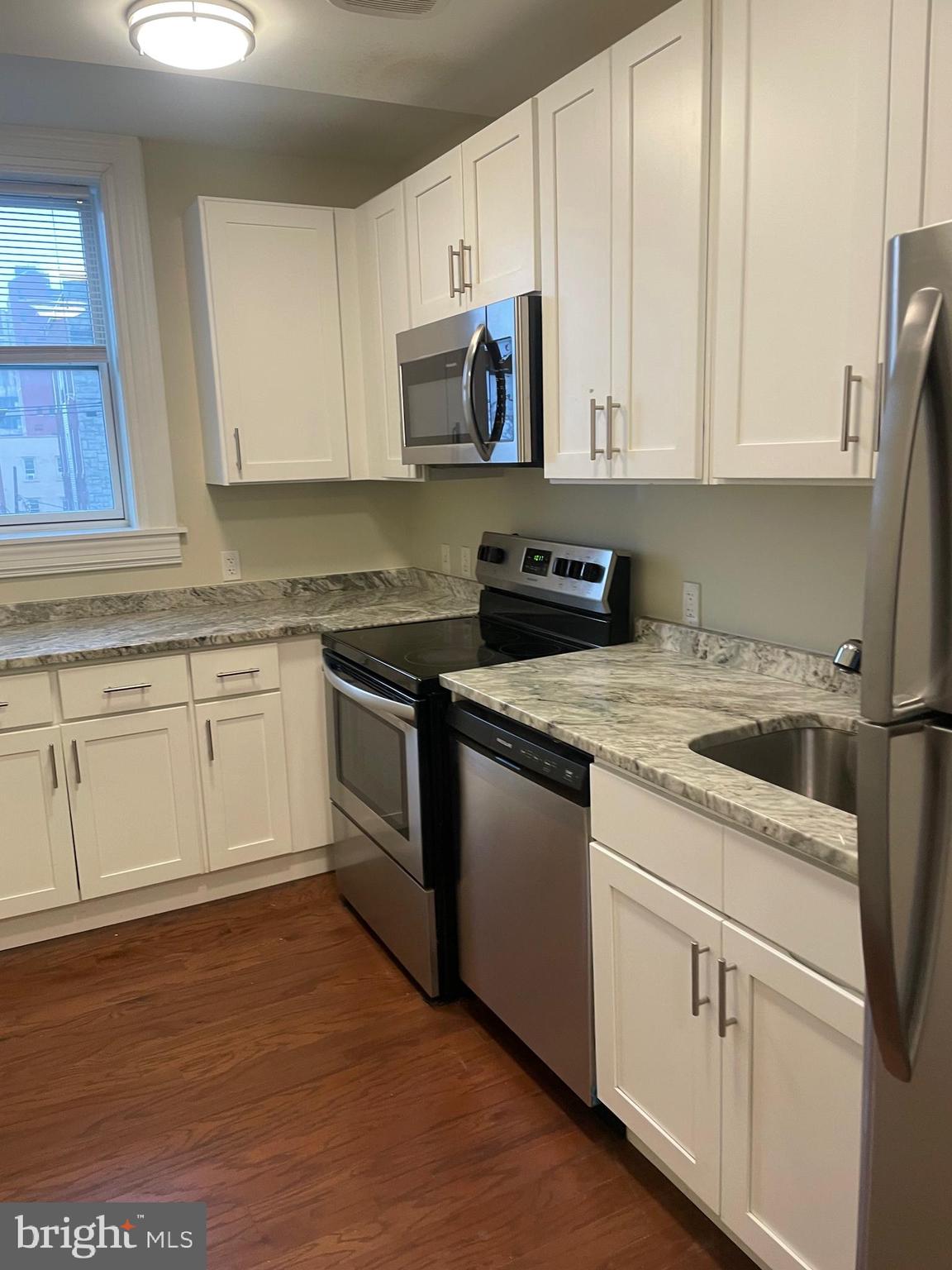 306 Cooper Street, Unit 505 Camden, NJ 08102 - Photo 7 of 19 a kitchen with granite countertop white cabinets and white appliances