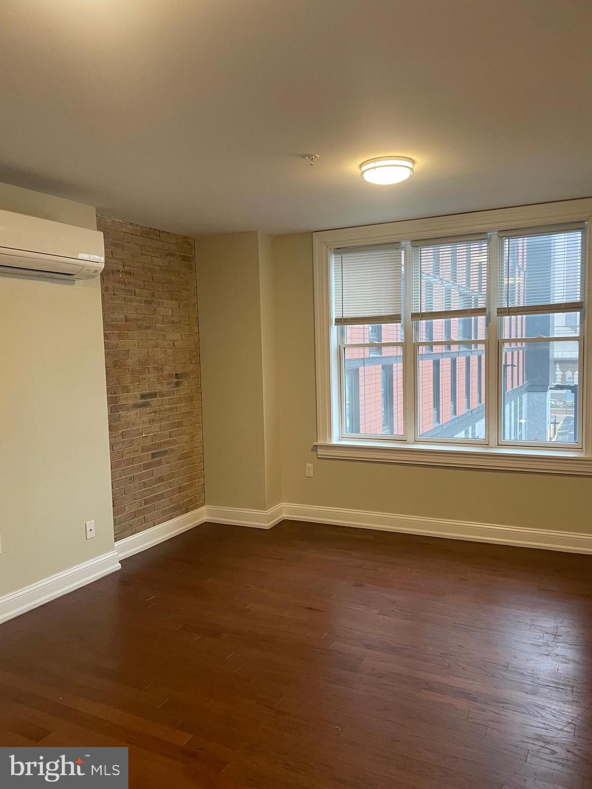 306 Cooper Street, Unit 505 Camden, NJ 08102 - Photo 9 of 19 an empty room with wooden floor and windows