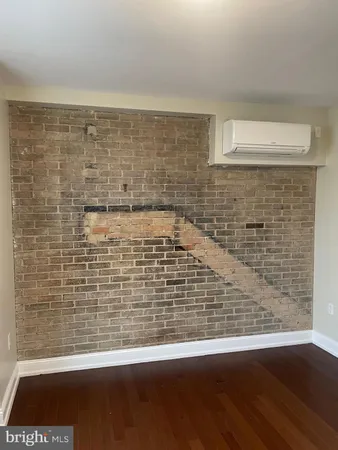 a view of a brick wall with wooden floor