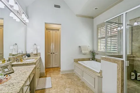 a spacious bathroom with a tub sink and mirror