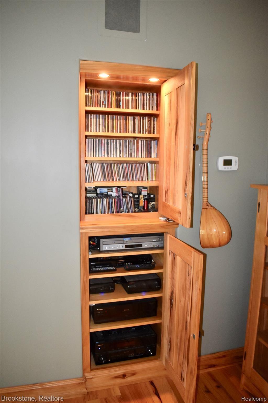 405 Baldwin Ridge Oxford, MI 48371 - Photo 25 of 54 ALL OF THE TRIM IN THE LARGE GREAT ROOM (19X23) IS MILLED FROM HICKORY HARVESTED FROM THE PROPERTY. THIS BUILT-IN CABINET CONTAINS ALL OF THE ELECTRONICS FOR THE 7.1 SURROUND THEATRE SYSTEM