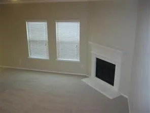 a view of empty room with a fireplace