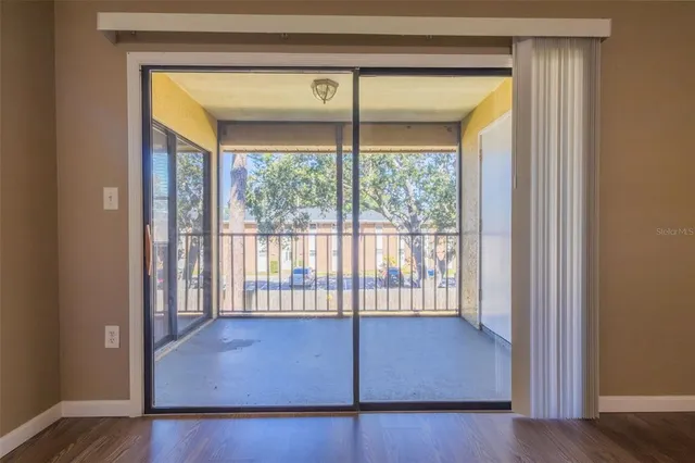 a view of a room that has wooden floor and a window