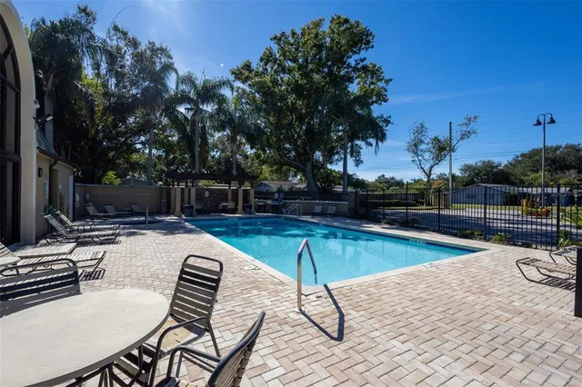 a view of a swimming pool with a lounge chair and palm trees