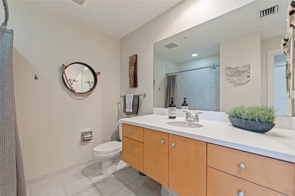 a bathroom with a granite countertop sink mirror vanity and toilet