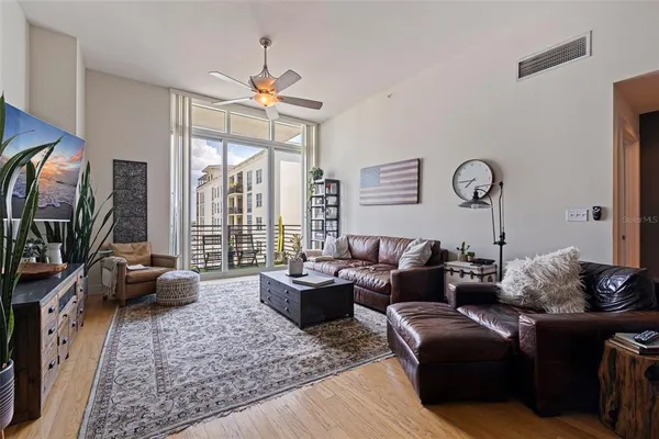 a living room with furniture large window and a flat screen tv
