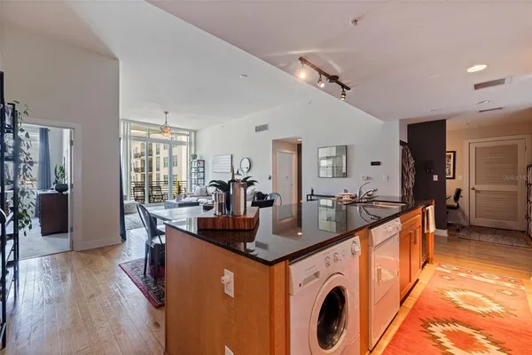 a kitchen with stainless steel appliances granite countertop a sink a stove and a wooden floors
