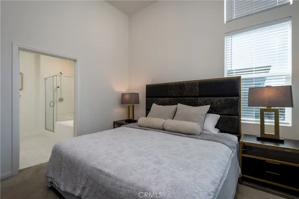 a large bed in a bedroom next to a window
