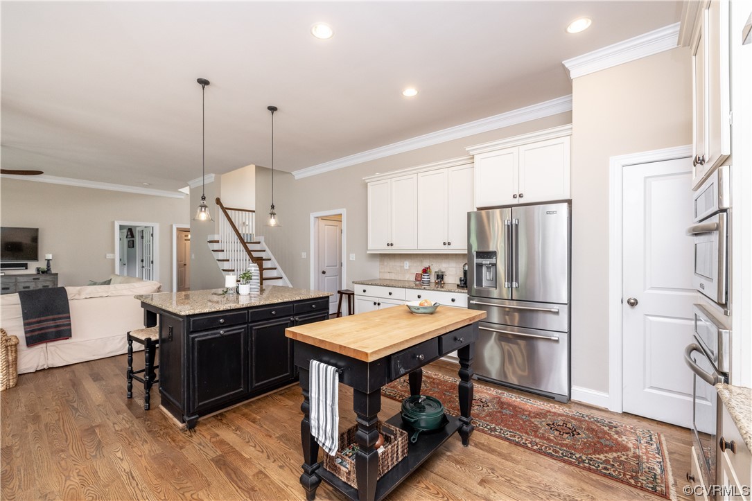 11724 Winterpock Road Chesterfield, VA 23838 - Photo 17 of 50 a kitchen with stainless steel appliances a stove a refrigerator a sink and dishwasher with wooden floor