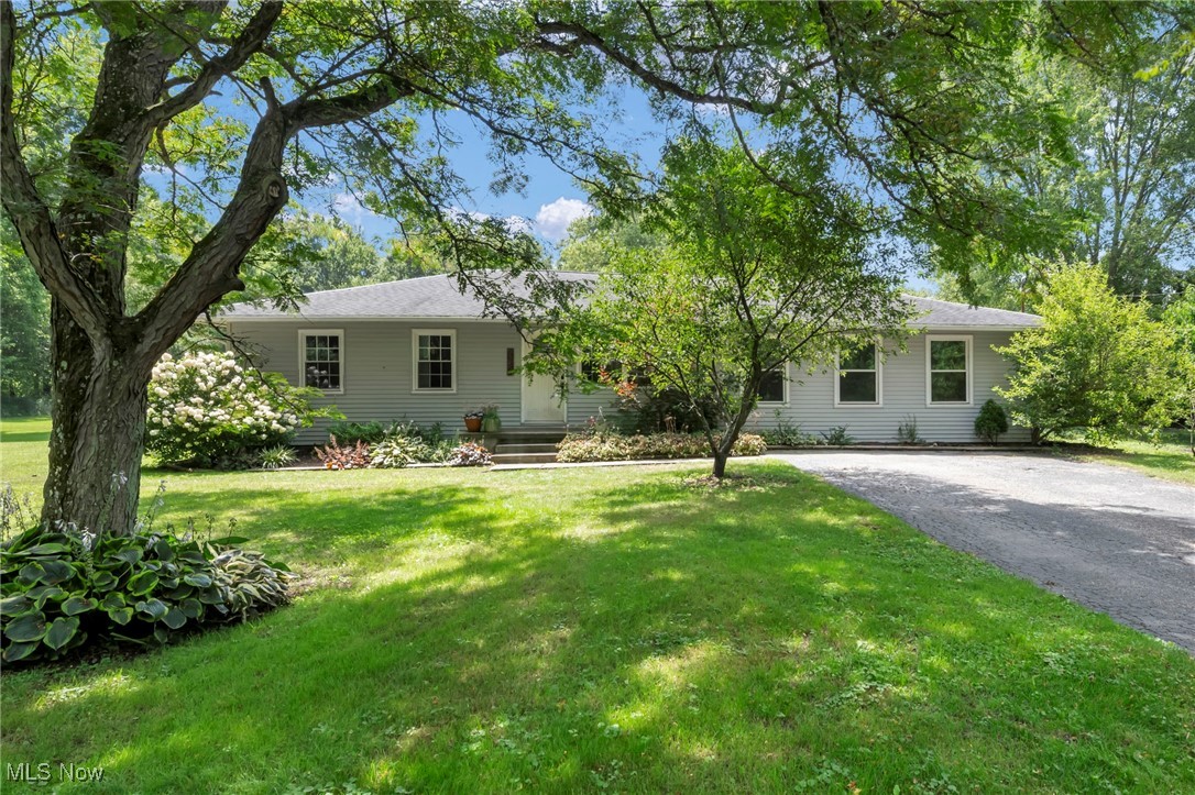 Ranch-style house featuring a front lawn and driveway