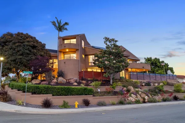 a front view of a house with a yard and potted plants