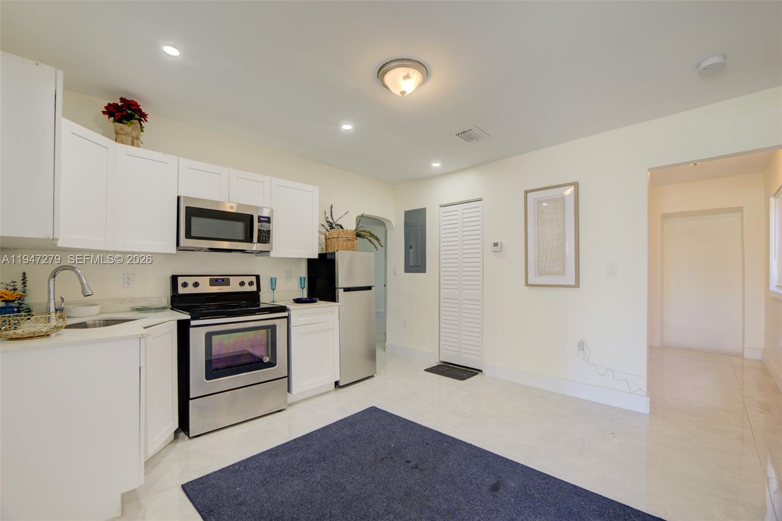 742 Northwest 70th Street, Unit 1 Miami, FL 33150 - Photo 2 of 30 a kitchen with stainless steel appliances granite countertop a stove a sink and a refrigerator