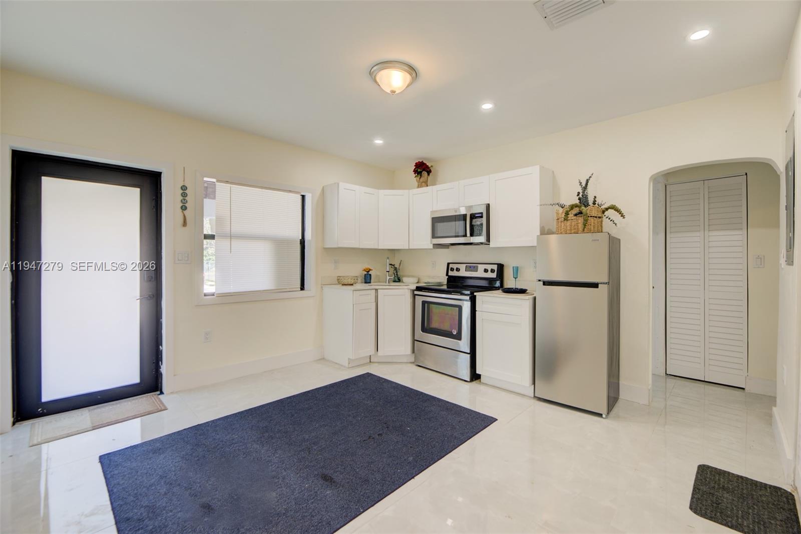 742 Northwest 70th Street, Unit 1 Miami, FL 33150 - Photo 3 of 30 a kitchen with white cabinets and refrigerator