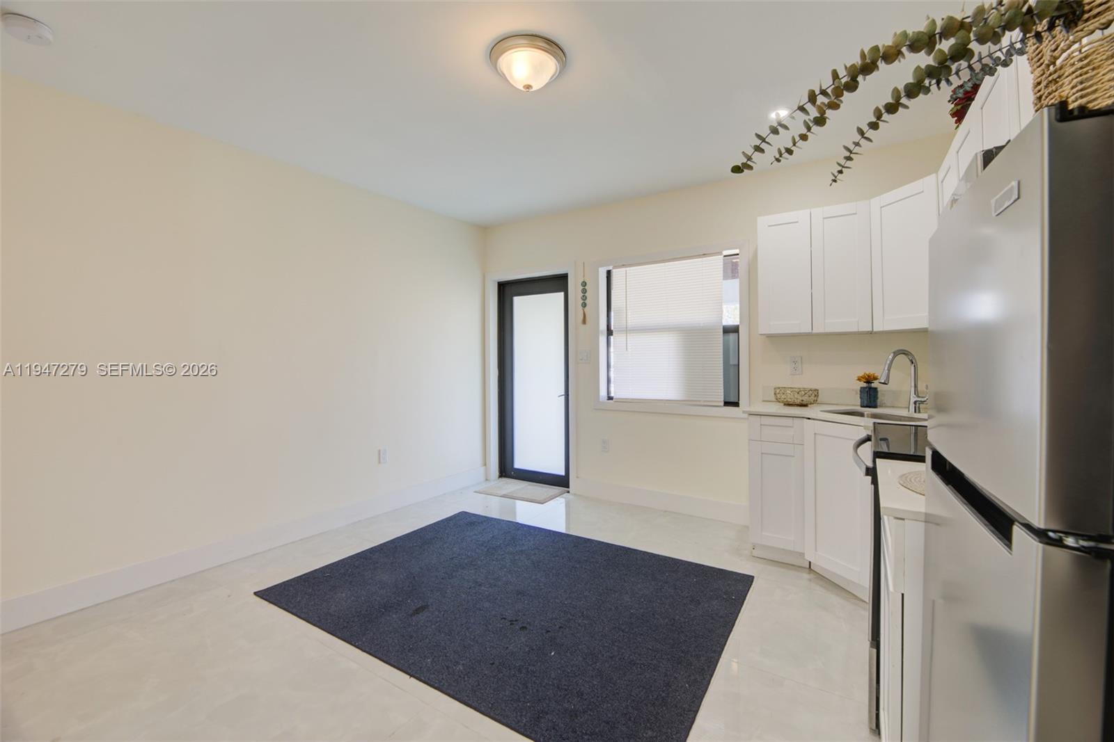 742 Northwest 70th Street, Unit 1 Miami, FL 33150 - Photo 4 of 30 a kitchen with a refrigerator and white cabinets