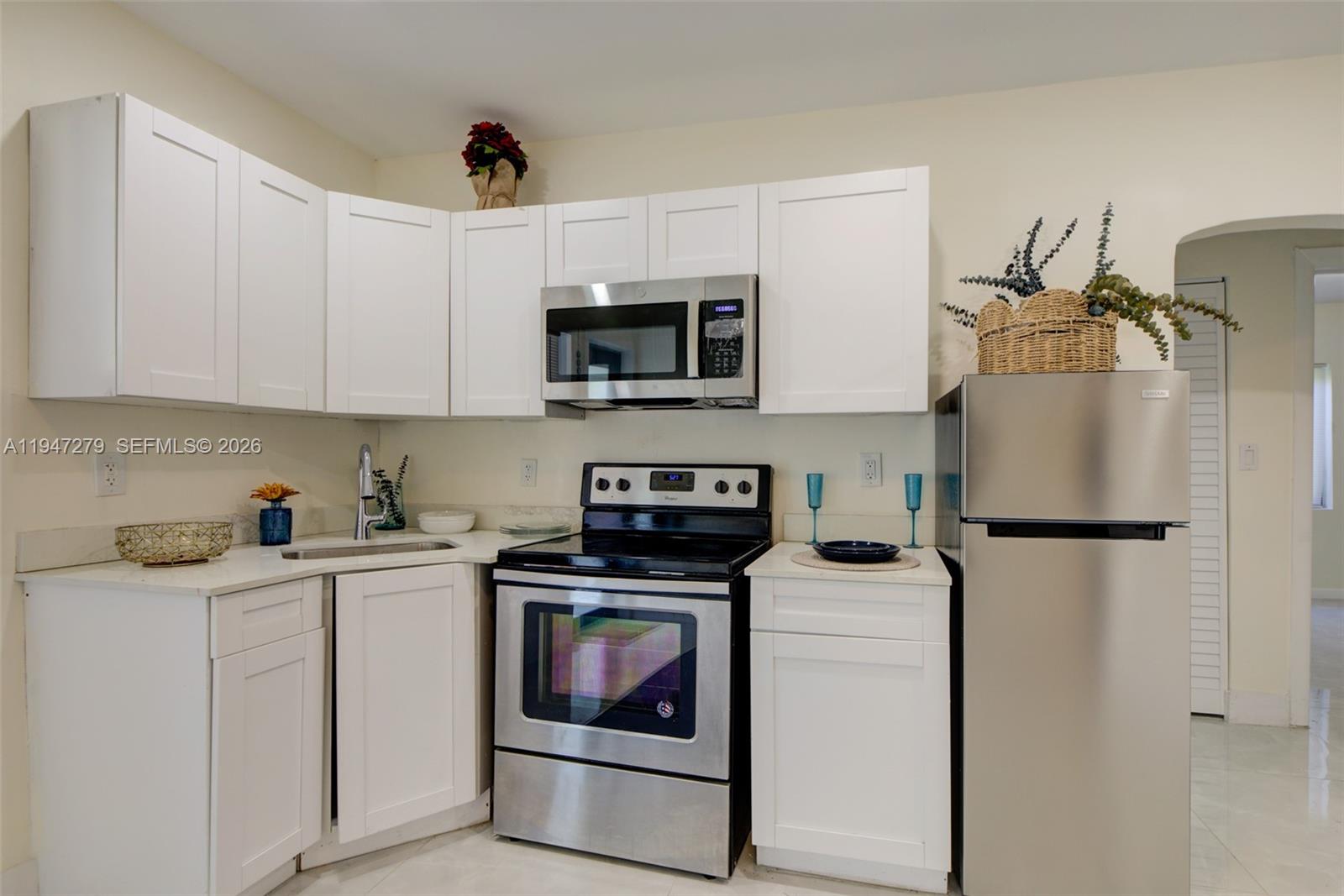 742 Northwest 70th Street, Unit 1 Miami, FL 33150 - Photo 5 of 30 a kitchen with a stove a sink and a refrigerator