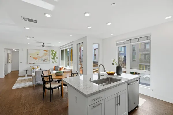 a kitchen with stainless steel appliances granite countertop a table and chairs