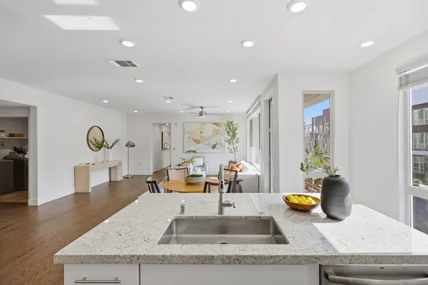 a kitchen with stainless steel appliances granite countertop white cabinets a stove a sink and a refrigerator