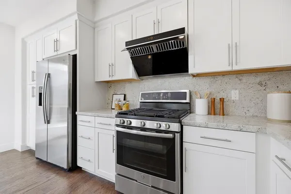 a kitchen with granite countertop white cabinets and black appliances
