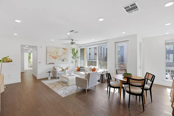 a living room with furniture wooden floor and a large window