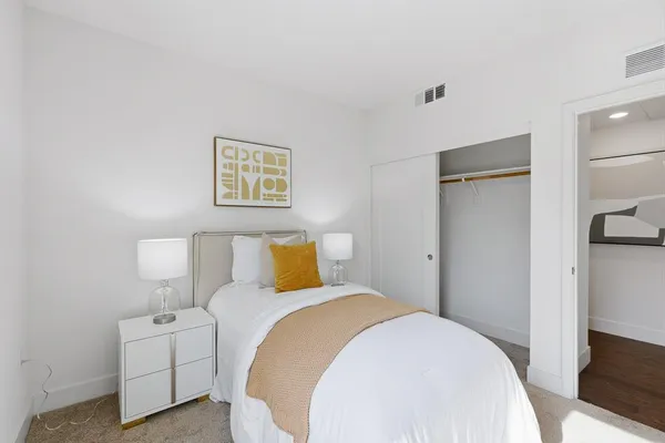 a bedroom with bed and a potted plant