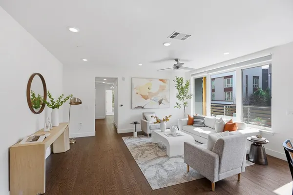 a living room with furniture a large window and a chandelier