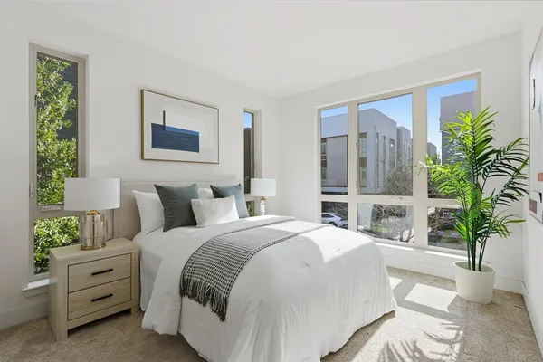 a bedroom with furniture and a large window