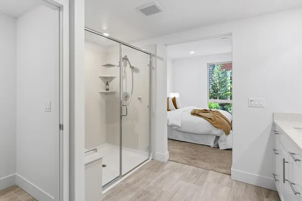 a bathroom with a granite countertop toilet and a shower