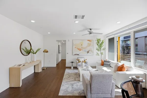 a living room with furniture a chandelier and a large window