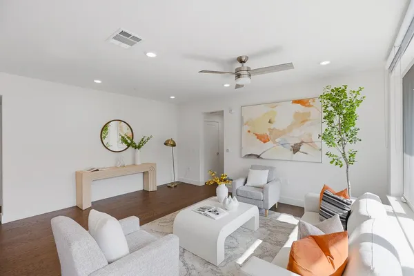 a living room with furniture a rug and a potted plant