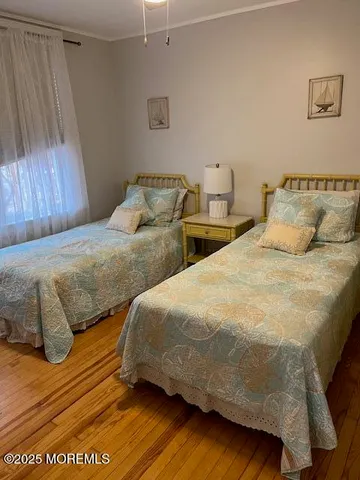 a bedroom with two beds and wooden floor