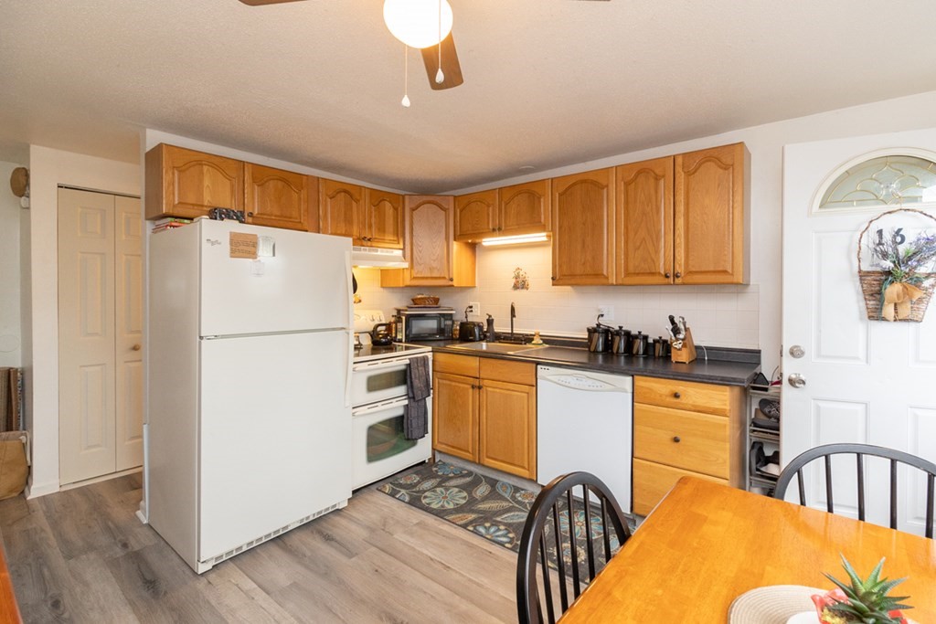 269 Chicopee Street, Unit 16 Chicopee, MA 01013 - Photo 12 of 26 a kitchen with stainless steel appliances granite countertop a refrigerator a stove a sink dishwasher and a dining table with wooden floor