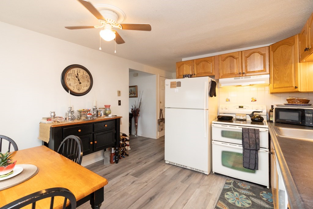269 Chicopee Street, Unit 16 Chicopee, MA 01013 - Photo 10 of 26 a kitchen with stainless steel appliances granite countertop a refrigerator a stove a sink dishwasher a dining table and chairs with wooden floor