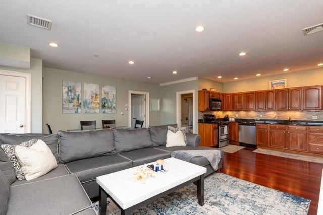 a living room with furniture and kitchen view