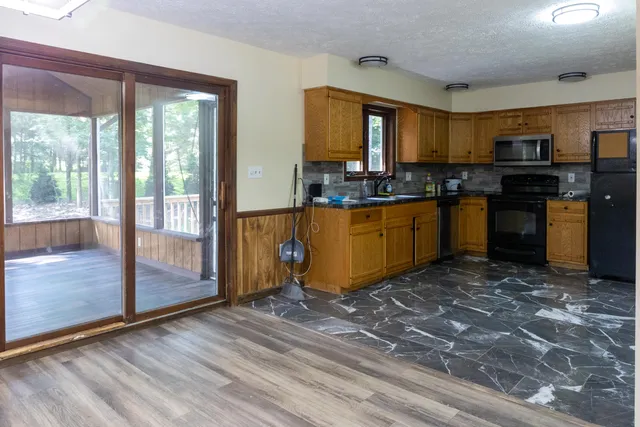 a kitchen with stainless steel appliances granite countertop a refrigerator stove top oven and sink