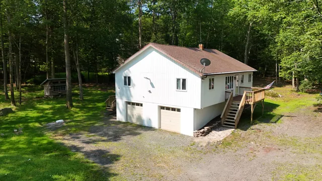 a view of a small house in the middle of a yard