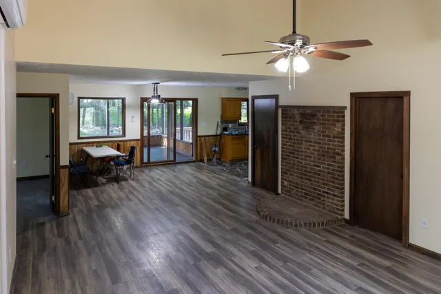 a view of a livingroom with furniture wooden floor ceiling fan and windows