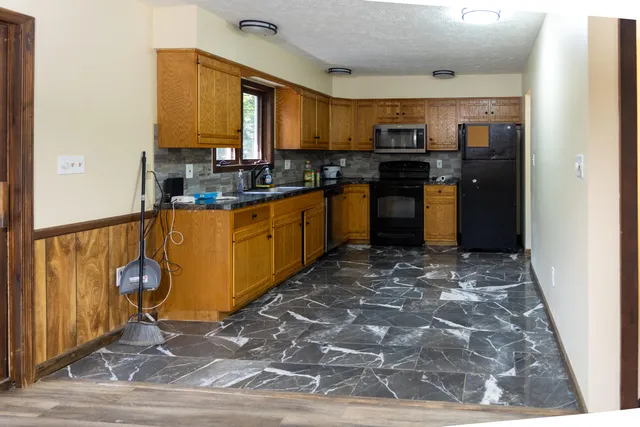 a kitchen with stainless steel appliances granite countertop a refrigerator stove top oven and sink