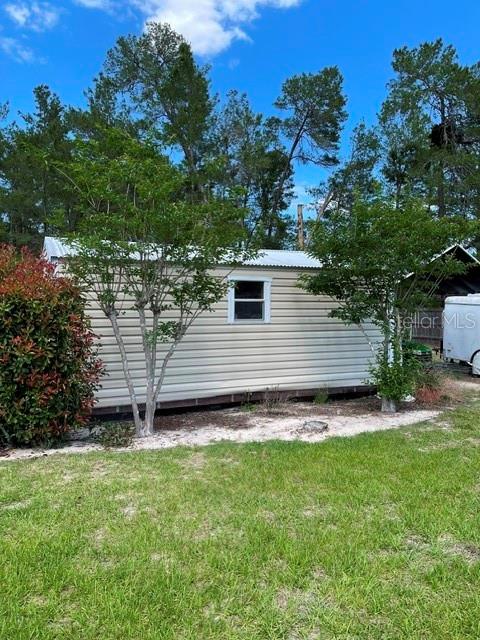 10985 Southwest 48th Terrace Ocala, FL 34476 - Photo 64 of 73 a view of a backyard with plants and a large tree