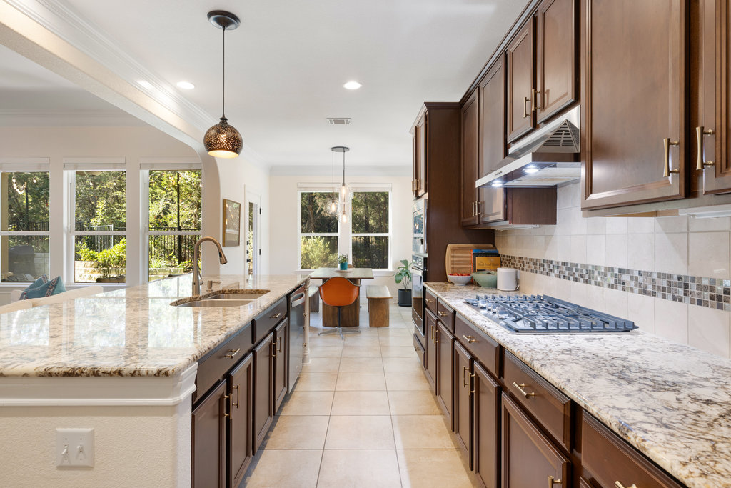 9116 Villa Norte Drive Austin, TX 78726 - Photo 31 of 40 a kitchen with stainless steel appliances granite countertop sink stove and cabinets