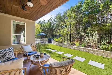 a front view of a house with swimming pool and chairs