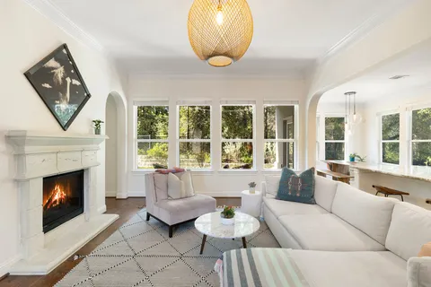 a living room with furniture a fireplace and a large window