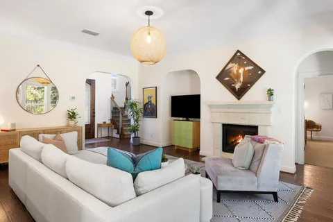 a living room with furniture a large window and a fireplace