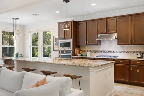 a kitchen with granite countertop a stove refrigerator and microwave