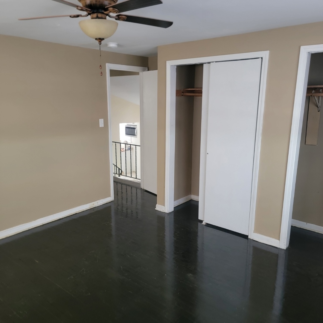 16444 Wolcott Avenue Markham, IL 60428 - Photo 11 of 18 an empty room with wooden floor and a ceiling fan