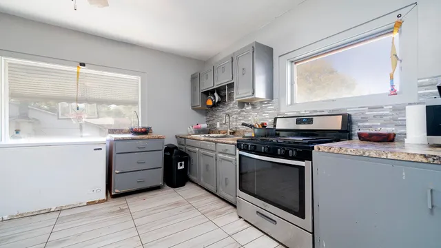 a kitchen with a stove a sink and a window
