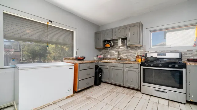a kitchen with stainless steel appliances granite countertop a stove a sink and a microwave