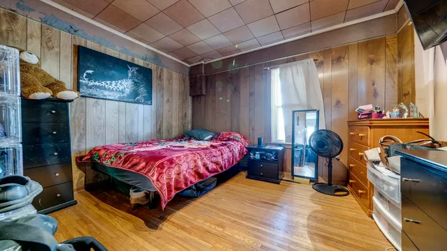 a spacious bedroom with a bed and wooden floor