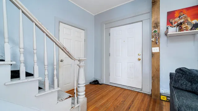 a view of entryway with wooden floor and livingroom view