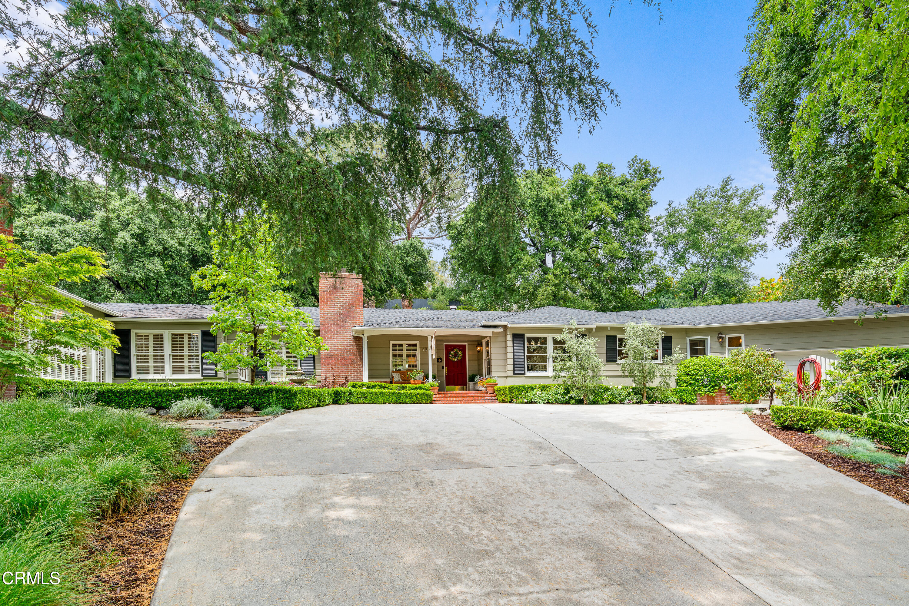 a front view of a house with a yard and potted plants
