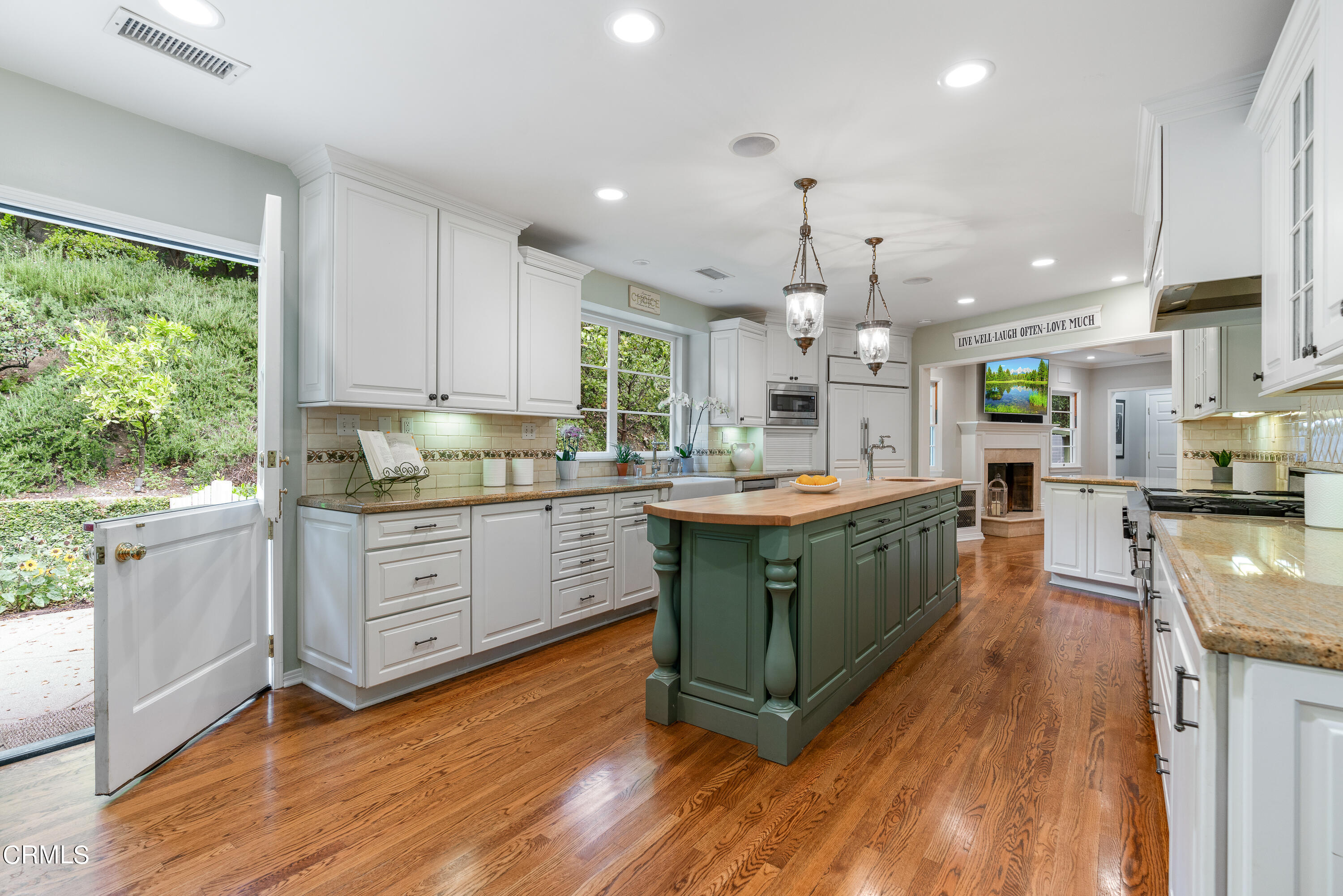 1265 Inverness Drive Pasadena, CA 91103 - Photo 13 of 44 a kitchen with kitchen island granite countertop a sink cabinets and wooden floor